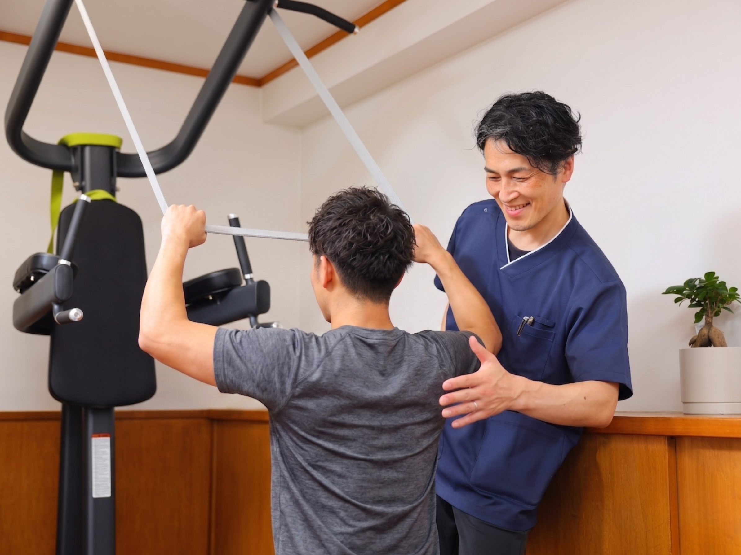 30代から40代の利用者とトレーナーが広いトレーニングスペースで体幹トレーニングを行っている様子