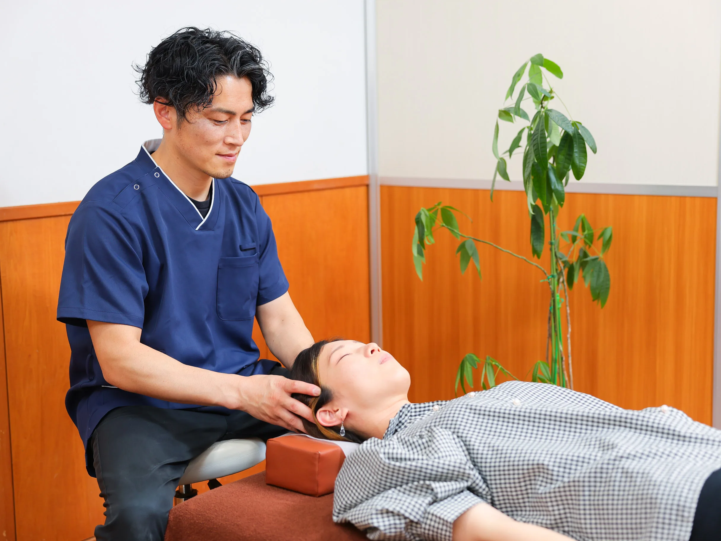 施術ベッドで利用者の頭部を確認している様子