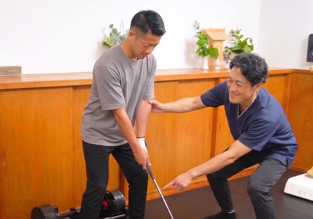 ゴルフクラブを持つ利用者が回旋トレーニングを行い、トレーナーが足元と骨盤の向きを確認している場面