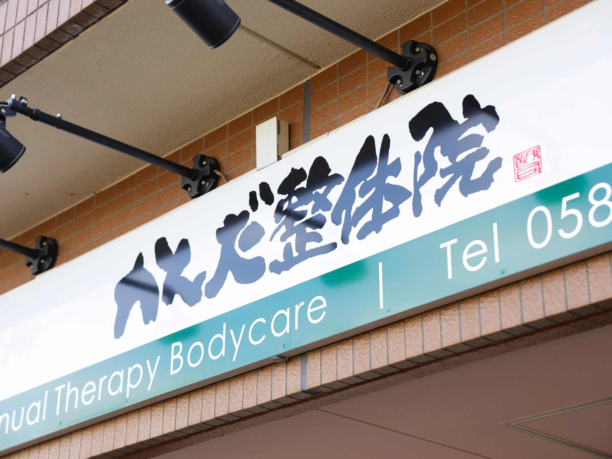 トレーニングマシンの横で利用者が体幹を意識した姿勢保持を行う横向きのカット
