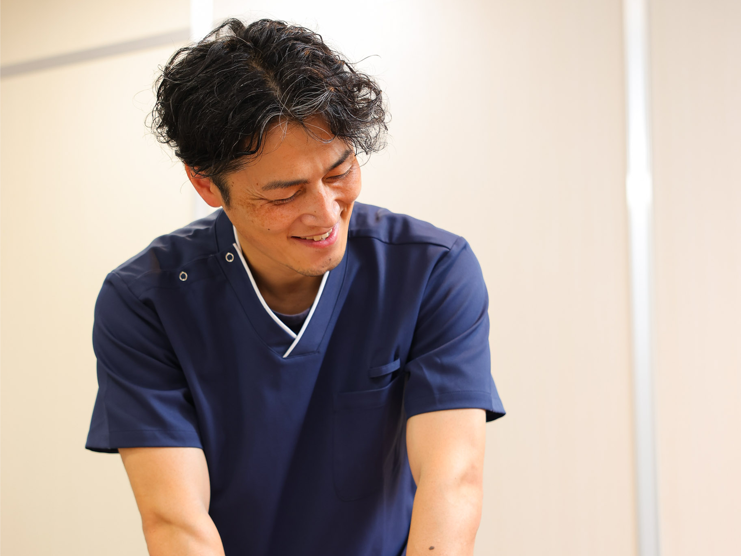 明るい室内でトレーナーがゴルフ動作に合わせた回旋トレーニングを指導している様子